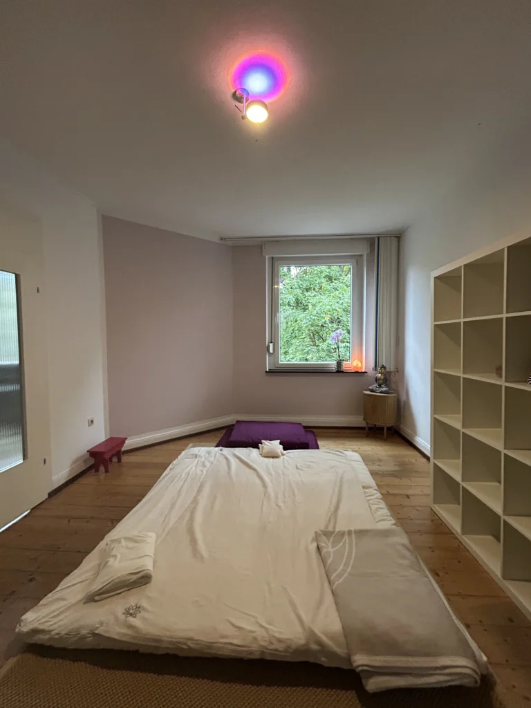 Shiatsu Krefeld Raum mit Futonmatte, wei&szlig;em Regal, kleinem Schr&auml;nkchen und Budda